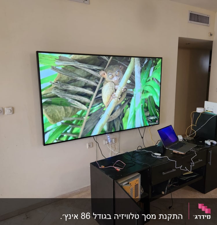 טלוויזיה תלויה על הקיר עם כבלים מחוברים
